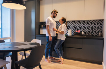 Young couple hugging at home in the kitchen relationship marriage life together