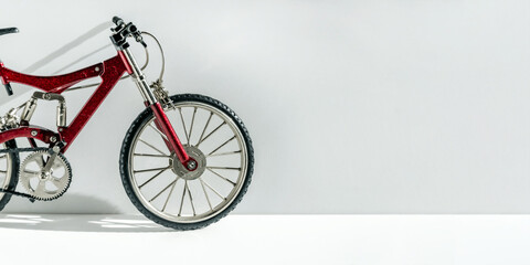 Close-up realistic model of a toy metal full-suspension mountain bike. Miniature bicycle on a white...