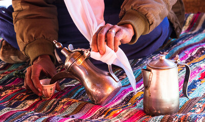 Photo of traditional arabic tea pot and cup. Bedouin tea, traditional tea - obrazy, fototapety, plakaty