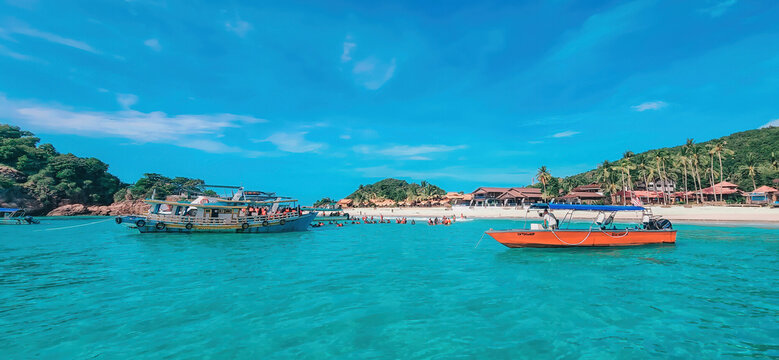 Redang, Malaysia - May 10, 2022  Boats, turquoise water and white sand beach, Redang Island, Malaysia