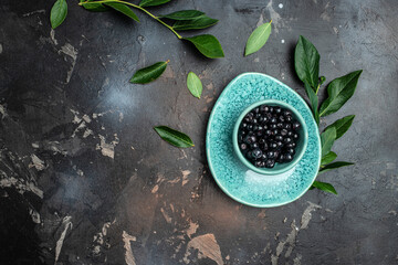 Superfoods antioxidant of indian mapuche. Bowl of fresh maqui berry on dark background, top view