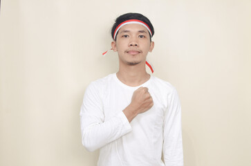 Young Indonesian man with hands on chest celebrating independence day