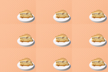 seamless texture, pattern with piece of biscuit cake with chocolate, cream, marzipan on white plate, isolated peach background, calorie sweets concept, unhealthy food, homemade baking for wallpaper