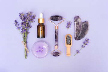 Amethyst gua sha roller and scraper for facial massage with bottle of face serum or lavender...