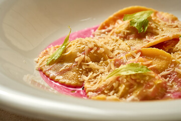 Ravioli with stuffing in pink sauce. Close-up. Selective focus. Noise in post-production