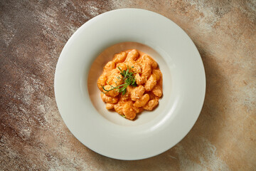 Gnocchi in tomato sauce and parmesan. Close-up. Selective focus. Noise in post-production