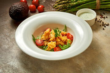 Fish in batter fried in oil with sauce. Close-up. Selective focus. Noise in post-production