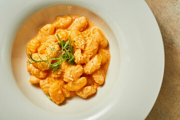 Gnocchi in tomato sauce and parmesan. Close-up. Selective focus. Noise in post-production