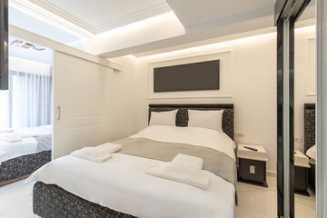 Interior of a luxury double bed hotel bedroom with black and white furniture