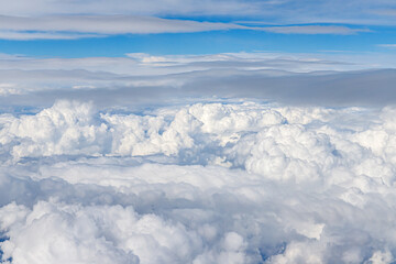 Clouds from above. View from airplane.  blue sky view from plane. sky wallpaper with space for your text . Aerial view of the blue sky. High in the Heavens.   View from Airplane Window