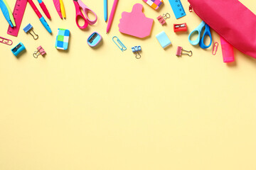 Back to school concept. Frame made of school essentials on yellow background. Flat lay, top view, copy space.