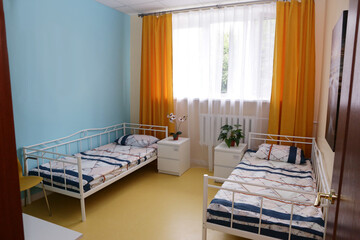 interior corner of hospital for elderly people ward with bedside table and curtain close up photo