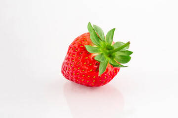 Fresh organic strawberries on a white reflective surface. Close up shot.