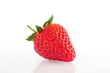 Fresh organic strawberries on a white reflective surface. Close up shot.