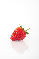 Fresh organic strawberries on a white reflective surface. Close up shot.