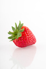 Fresh organic strawberries on a white reflective surface. Close up shot.