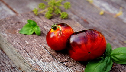 dark red fresh tomatoes close-up on wooden board selective and soft focus