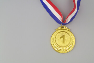 Golden medal with ribbon on grey background with copy space for text