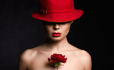 Fototapeta premium Beautiful young Woman In Hat and Flower. Lovely girl with make-up and Rose