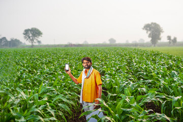 young indian farmer using a smart phone