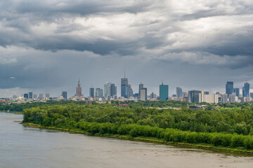 Moody sky over distant skyline of Warsaw city center and Vistula river aerial landscape
