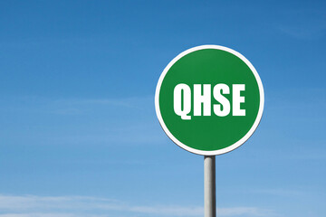 'QHSE' sign in green round frame. Blue sky is on background