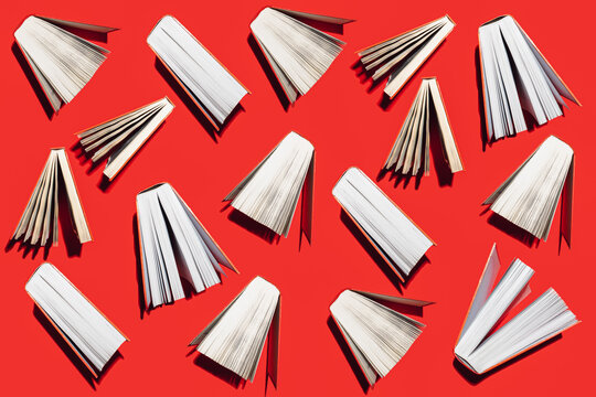 Creative pattern made of red books on vibrant red background. Education and knowledge concept. Flat lay.