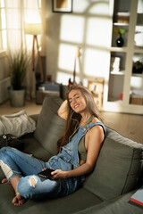 Obraz premium Young woman at home. Beautiful girl listening the music while drinking coffee