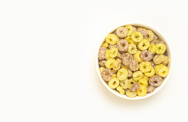 An image isolated and top view many colors such as yellow and pink cereal in the bowl is a breakfast food fresh with copy space for text.