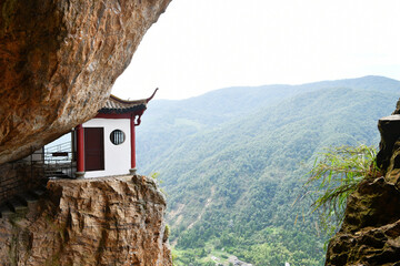 a traditional Chinese style house on the edge of a cliff in the mountains, Zhejiang Province, China