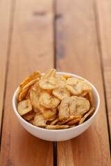 Close-up of Crunchy salty banana chips in white bowl, made fried banana,  Indian salty snacks (Namkeen),