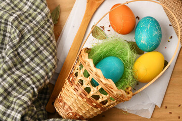 easter eggs in a nest of grass in a basket, wooden background, holiday still life and decorations