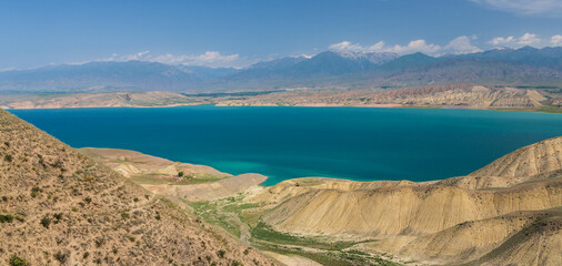 Fototapeta na wymiar Toktogul reservoir and desert mountains amoung it. It is one of the largest reservoirs in Central Asia, located in the northern part of the Jalal-Abad Region. Kyrgyzstan