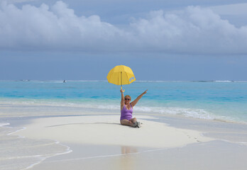 old bikini woman with umbrella on sea sand