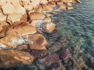 Seashore with large boulders. Mediterranean Sea coast, Cyprus. Rocky shore with clear blue water.