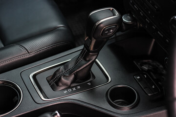 Fototapeta na wymiar automatic transmission shift selector in the car interior. Closeup a manual shift of modern car gear shifter. 4x4 gear shift