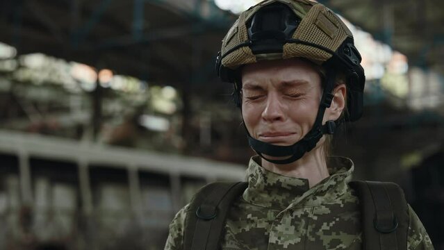 Military woman soldier in uniform and helmet crying while having hard moment during military operation. Concept of people, war and losts.