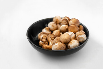 mushrooms champignon in  bowl on white background