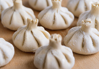 Raw frozen khinkali  on wooden table. Process preparation georgian meal. food concept.