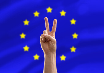 politics and gesture concept - close up of male hand showing peace over flag of european union on...