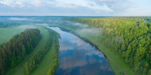 Fototapeta premium Aerial panoramic landscape with sunset over the river and beautiful clouds on the sky.