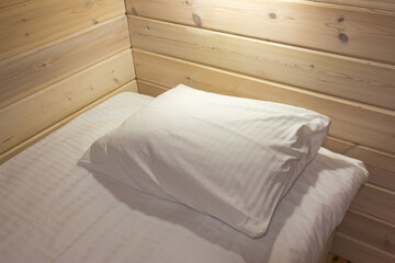 Fototapeta na wymiar Prepared fresh bed in a wooden house, scene in hotel room.