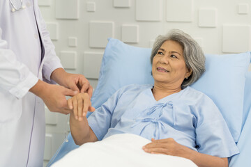 Doctor taking care elderly asian woman on bed at the hospital. People and health care concept