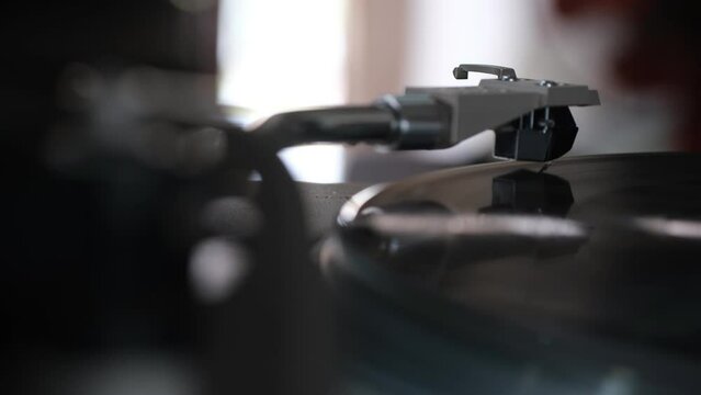 Focus on The Headshell Cartridge and Stylus of Classic Vintage Vinyl Record Player from behind and Playing on Vinyl Record Music