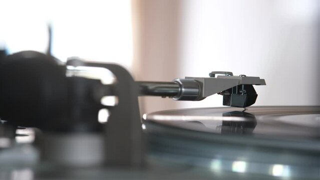 Focus on The Headshell Cartridge and Stylus of Classic Vintage Vinyl Record Player from behind and Playing on Vinyl Record Music