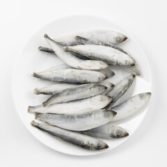 A plate of frozen sea wild fish with vitamin omega. Raw herring for cooking.