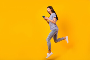 Fototapeta na wymiar Full size profile portrait of charming person jump hold telephone chatting isolated on yellow color background