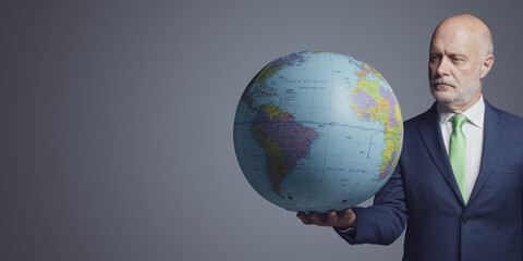 Corporate businessman holding a globe