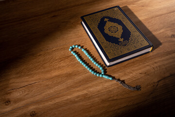 Islamic concept - The Holy Al Quran with written Arabic calligraphy meaning of Al Quran and rosary...