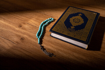 Islamic concept - The Holy Al Quran with written Arabic calligraphy meaning of Al Quran and rosary...
